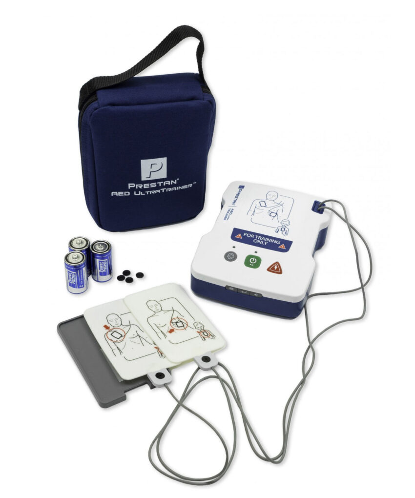 Simulador de desfibrilador externo automático DEA Prestan AED UltraTrainer em português sobre superfície clara